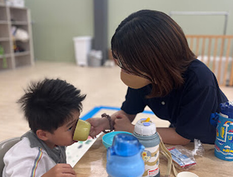 おやつを食べさせる職員