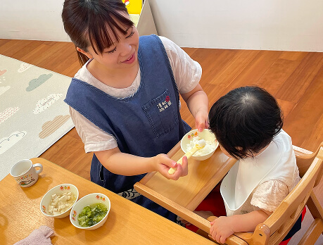 離乳食を食べさせる職員